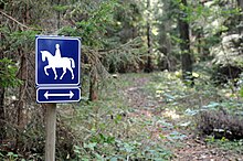 Panneau indicateur bleu avec un pictogramme en forme de cavalier.