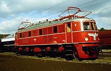 An E19 class locomotive of Deutsche Reichsbahn. A large Nazi-era crest of an eagle carrying a swastika is prominent on the front of the locomotive.