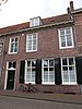 Pand, deel uitmakend van rij aaneengeschakelde 19e-eeuwse huizen, in bocht van de singel gelegen onder een rechte daklijst. Harmonische raamverdeling met luiken