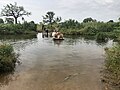 Darfur'da bir köylü taşmış dereyi geçerken. Yağmur mevsiminde akarsular sıkça taşmaktadır.