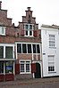 Huis met kleine trapgevel, met in onderpui metselmozaïek. Voormalig gebouw "De Doelen"