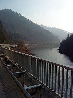 Durch die Talsperre hervorgerufener Stausee; die Talsperre befindet sich hinter dem Rechtsknick des Sees.