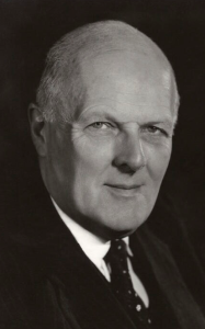 black and white photograph of clean shaven, bald, elderly white man