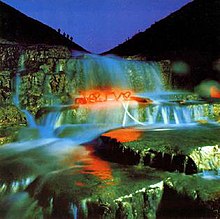 A close up of a waterfall with a neon sign that reads "Verve"