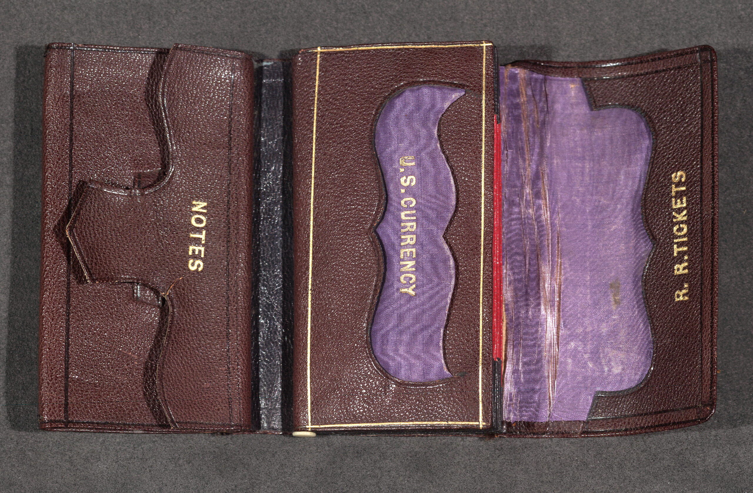 Photograph of Lincoln's brown leather wallet, with purpule silk lining, and separate pockets for notes, U.S. currency, and railroad tickets.