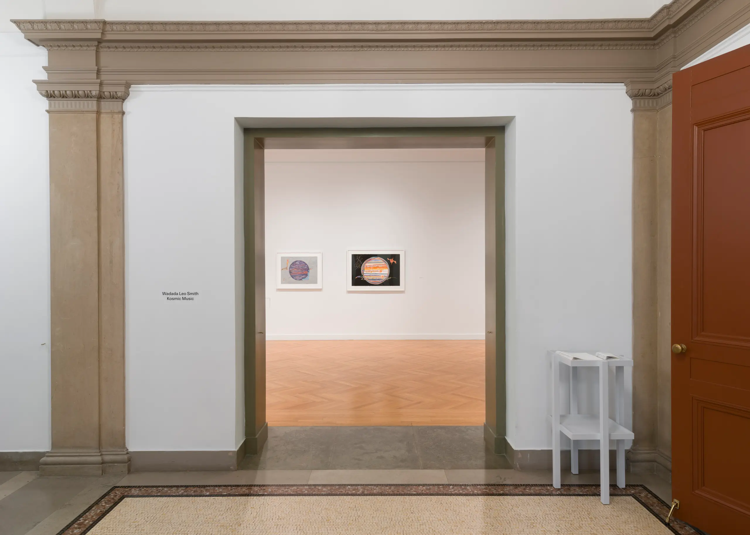 An open doorway leading to a gallery with drawings.