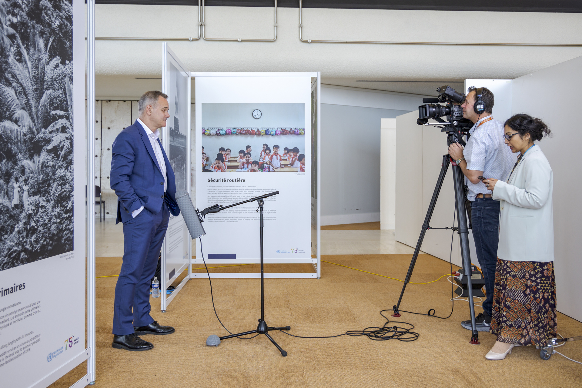 A man is being interviewed by a woman while being filmed