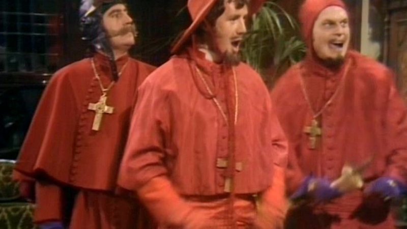 three men in red robes wearing wooden cross around their necks