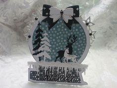 an ornament with a deer and snowflakes on it's side