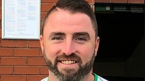 A headshot of Jim Crossley who has short brown hair and a brown beard. He is smiling at the camera.