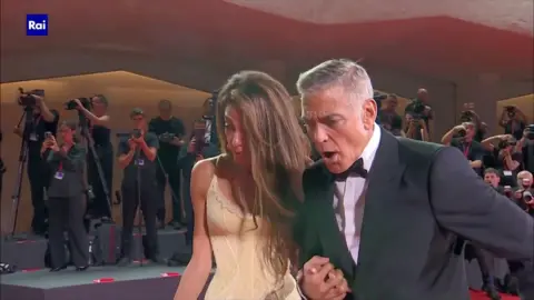 Amal and George Clooney appear shocked on seeing a photographer falling