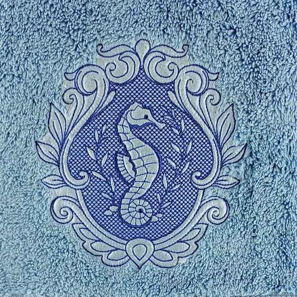 Seahorse embossed in blue embroidery thread on a blue hand towel