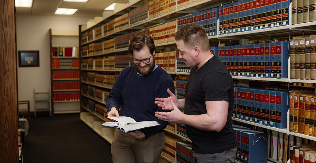 Students looking in book in library