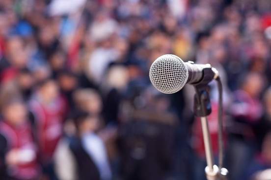 photograph of a microphone in front of blurred crowd