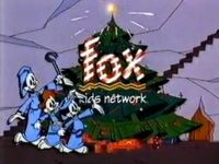 The Fox Kids logo (1992-1996) in front of a Christmas tree with Yakko, Wakko and Dot from Animaniacs.