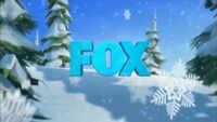 The FOX logo surrounded by snowy trees and snowflakes, as seen in a promo for Ice Age: A Mammoth Christmas.