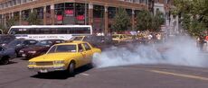 John McClane driving a taxi in Manhattan racing to Wall Street Station.