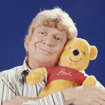 Sterling Holloway holding a Pooh plush toy.