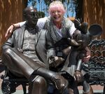 Russi Taylor standing behind the statues of Roy O. Disney and Minnie Mouse.