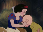 Dopey being kissed on the head by Snow White.