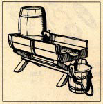 A small barrel mounted as a water reservoir for blacksmithing.