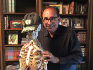 Stine posing with a skeleton wearing a Goosebumps hat in his apartment.