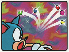 Illustration of the Sonic Blast Japanese manual, with Sonic in a shocked expression watching a Chaos Emerald shatter into five pieces.