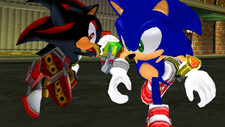 In-game screenshot of a Sonic Adventure 2: Battle cutscene, depicting Shadow, with a Chaos Emerald, running past Sonic in downtown Central City.