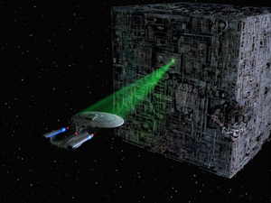 The Enterprise-D held captive by a Borg Cube's tractor beam.