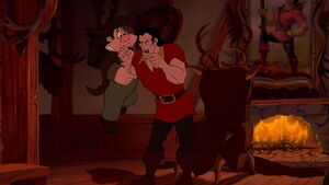 LeFou being held by Gaston.