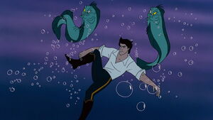 Flotsam and Jetsam releasing their grip on Eric after Flounder and Sebastian attack them.