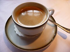 Kaffee in Porzellantasse mit Silberlöffel