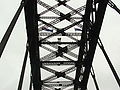 Top of the arch as seen from underneath. Australia and NSW flags are partially visible, as is a party of Bridgeclimbers crossing on the top framepiece