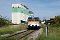 Deutsch: MAN-Schienenbus VT 26 bei der Ausfahrt auf dem Bahnhof Hüffenhardt vor dem Raiffeisen-Lagerhaus. English: MAN railbus leaving Hüffenhardt.