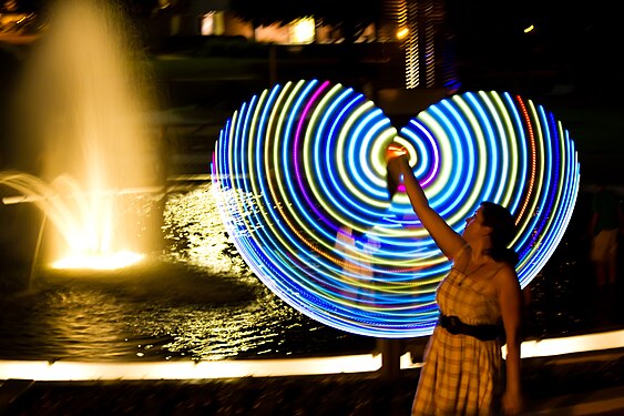 A girl twirls a light-up ring shaped baton.