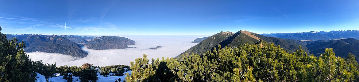 Ein Blick vom Hohen Fricken (Estergebirge) auf die östlichen Ammergauer Alpen in der linken Bildhälfte mit der Notkarspitze, Laber und Ettaler Manndl. Dazwischen das Loisachtal. Rechts im Foto Karwendel (Foto mit Bildbeschreibung).