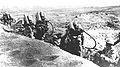 Flamethrower operators move back up the line after refilling their tanks with fuel. Iwo Jima, 1945.