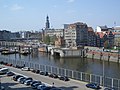 Blick über den Binnenhafen. Vorne das Nikolaisperrwerk am Kajen mit der Mündung des Nikolaifleetes. Im Hintergrund der Michel.