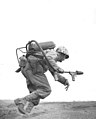 A flamethrower operator of Co. E, 2nd Bn, 9th Marines, runs under fire on Iwo Jima, February 1945.