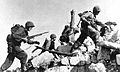 A heavily armed Marine assault team moves out on Okinawa. Spring 1945.