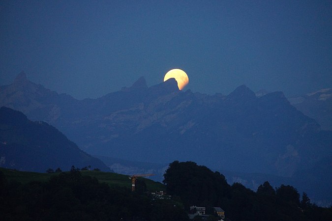 The full moon, lunar eclipse of 2017 August 7, behind mountains of Schwyzer Alpen (Rossstock)