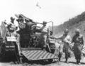 Lt. Gen. William M. Hoge, Commanding General, U.S. IX Corps, left, holds the lanyard which will fire the 75,000th shell to be fired by the corps since the start of the conflict in Korea, 25 June 1951.