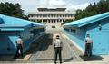 South Korean soldiers standing guard at the JSA between the blue buildings. View from the south, with North Korea to the rear.