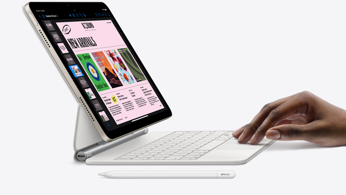 Vue latérale d’un iPad Air montrant l’app Keynote, fixé à un Magic Keyboard avec une main posée sur le trackpad et un Apple Pencil posé à côté.