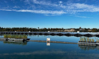 Blick auf einen See und viele PV-Module auf dem Wasser bei blauem Himmel