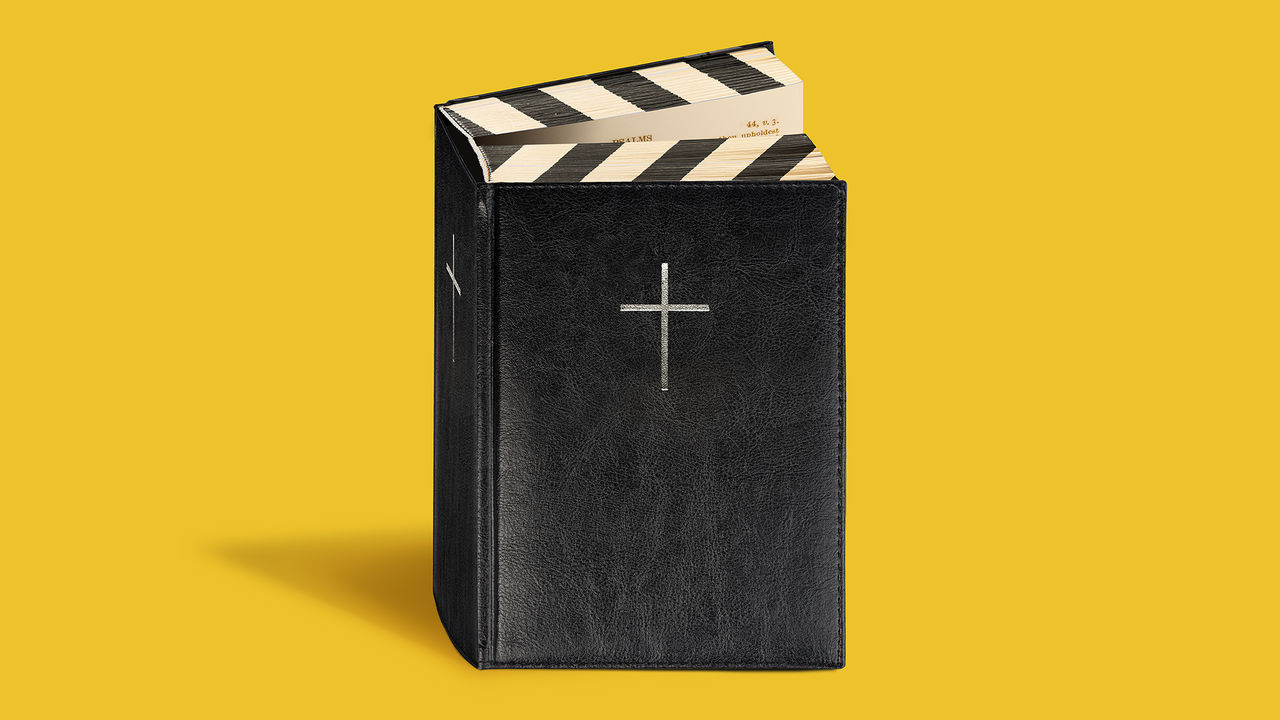 A black Bible with a silver cross, its pages shaped like a film clapperboard, against a yellow background