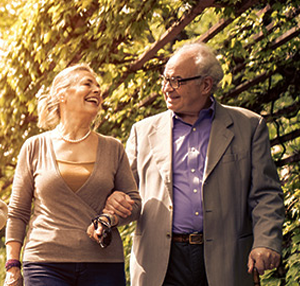 photo of elderly couple walking outside smiling