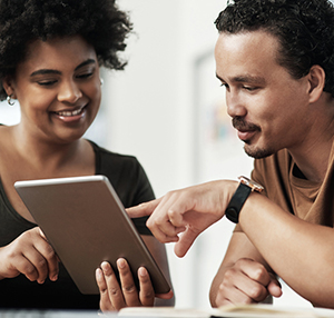 Two people looking at a tablet together