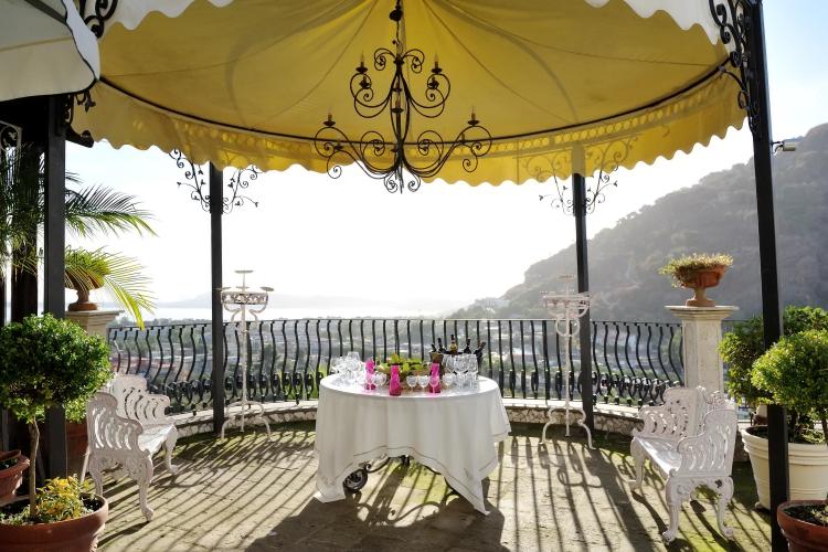 Wedding reception table with wine and glasses under a gazebo.