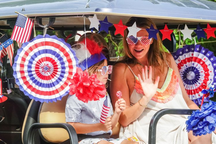 Family in decorated golf cart at Independence Day parade.